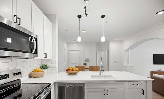 A modern kitchen with a stainless steel oven and a white countertop.