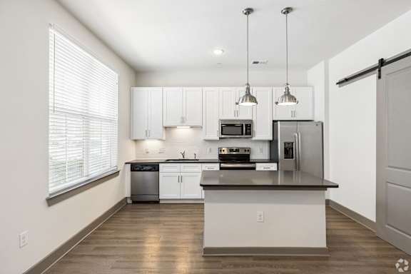 A modern kitchen with white cabinets and stainless steel appliances.