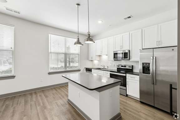 A modern kitchen with stainless steel appliances and white cabinets.