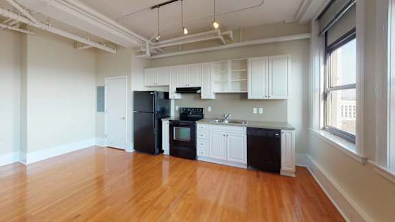 A kitchen with black appliances and white cabinets.