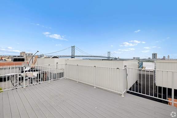 A balcony with a railing overlooks a bridge and buildings.