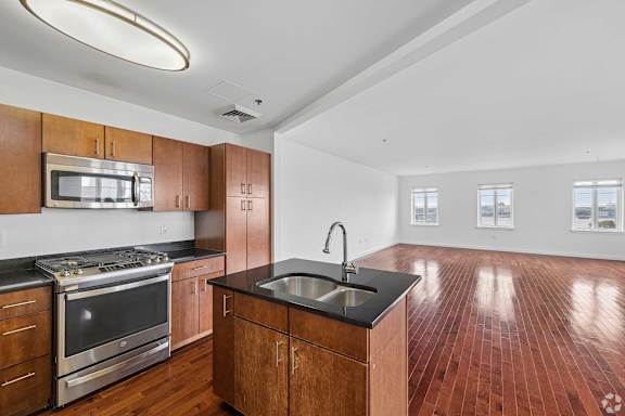 A kitchen with wooden cabinets and a black countertop.