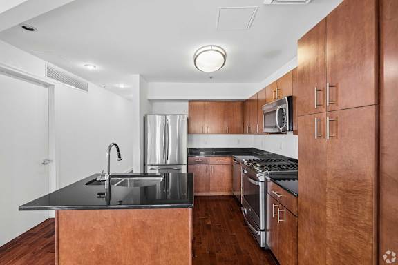 A modern kitchen with wooden cabinets and stainless steel appliances.