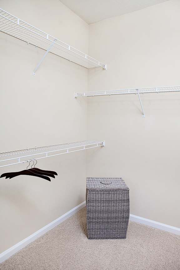 A room with a hanger and a box on the floor.