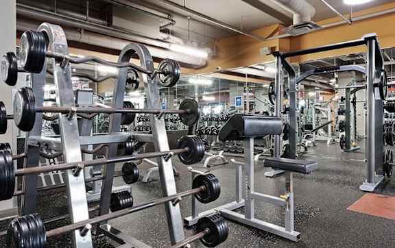A gym with a variety of weightlifting equipment.