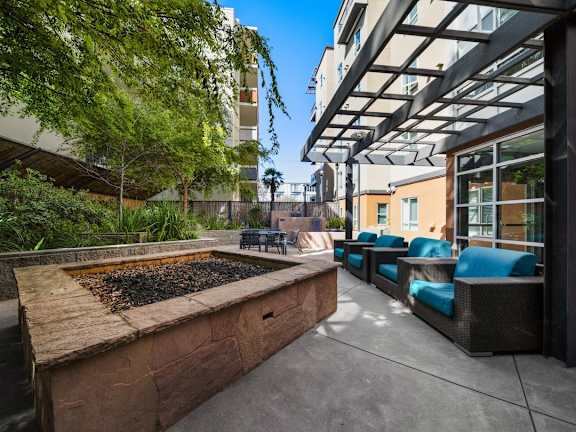 A patio with a fire pit and seating area.