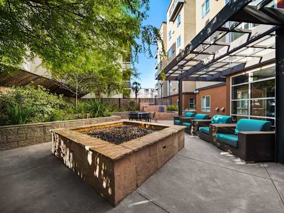 A large square planter with plants in it is in the middle of a patio.