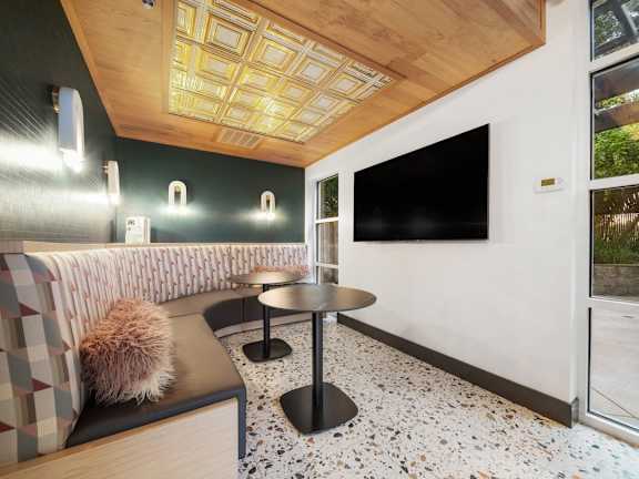 A modern room with a black table and a couch with a brown pillow.