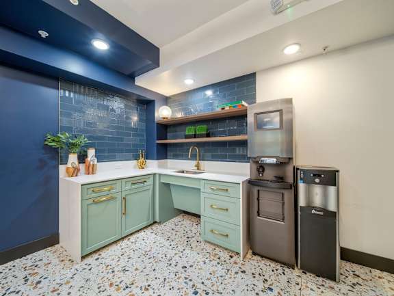 A kitchen with a blue wall and a tiled floor.