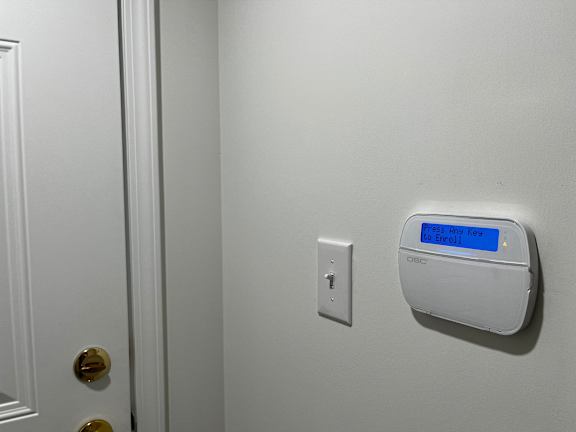 A white door with a white light switch and a white wall.