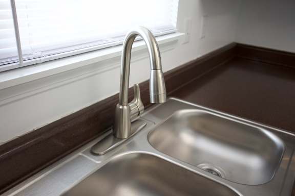 A modern kitchen sink with a chrome faucet.