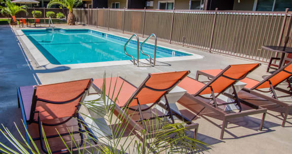 a pool with deck chairs and a poolside pool at Ella 1711 Apartments, Woodland, CA 95695