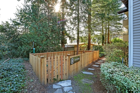 a wooden fence in front of a house with trees  at Townside Flats, Redmond, Washington