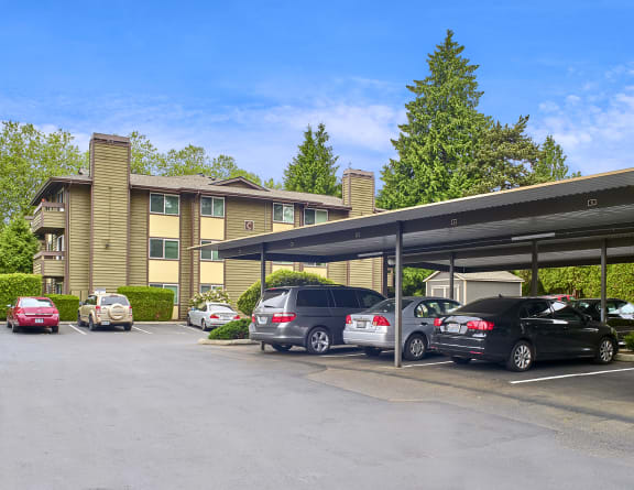 a parking lot with cars in front of an apartment building