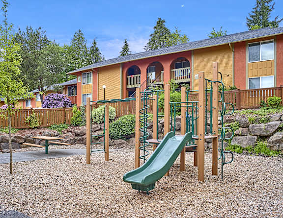 a playground with a slide in front of a house