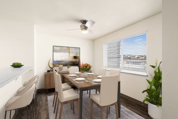 Dining area with table, chairs, plants and art with a large sunny window on right wall.at Clearwater, Post Falls Idaho