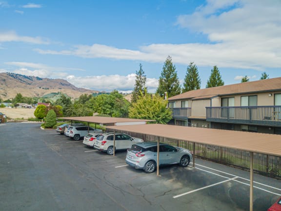 a parking lot with cars parked in front of a hotel building at Cedarwood, Wenatchee
