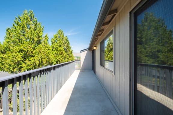 Large private balcony with trees and mountain range in the background at Cedarwood, Wenatchee