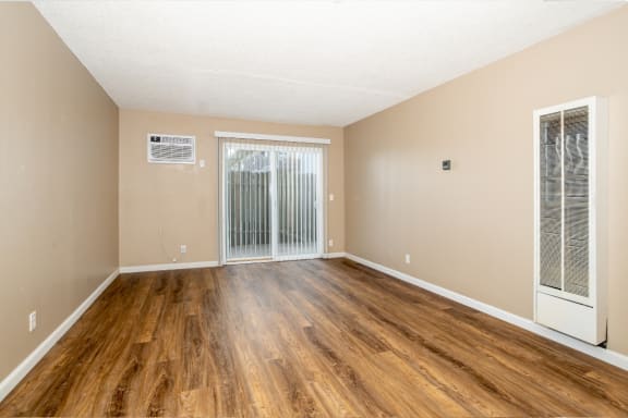 the spacious living room of an apartment with wood flooring and sliding glass doors at Ella 1711 Apartments, Woodland, CA 95695
