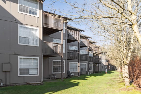 a row of apartment buildings with balconies and grass and trees at Capitol Crossing, Olympia, WA