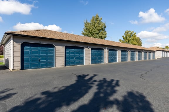 Long row of garages with blue doors lining a paved drive way in Richland, wa at Shoreline Village.