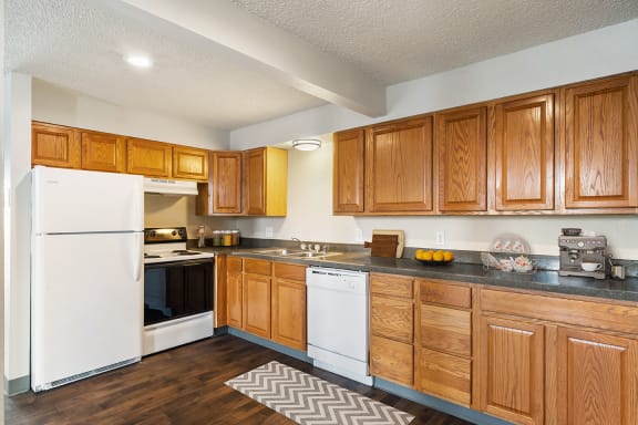 a kitchen with white appliances and wooden cabinets  at Wildflower, Kennewick, Washington