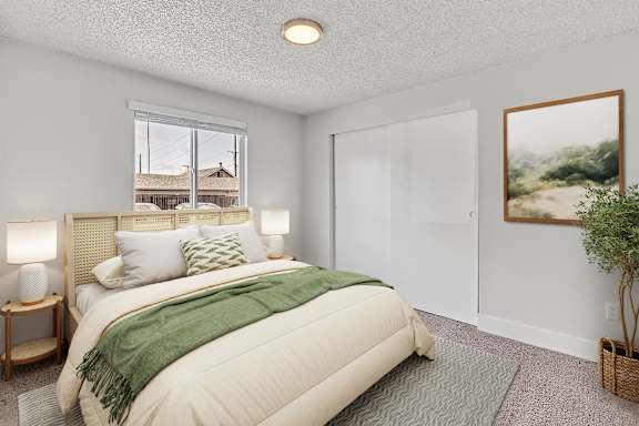 A bedroom with a large bed and a painting on the wall at Landing Apartments in Fife, WA..
