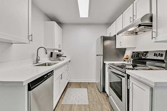A modern kitchen with white cabinets and stainless steel appliances at our Fife Apartments..