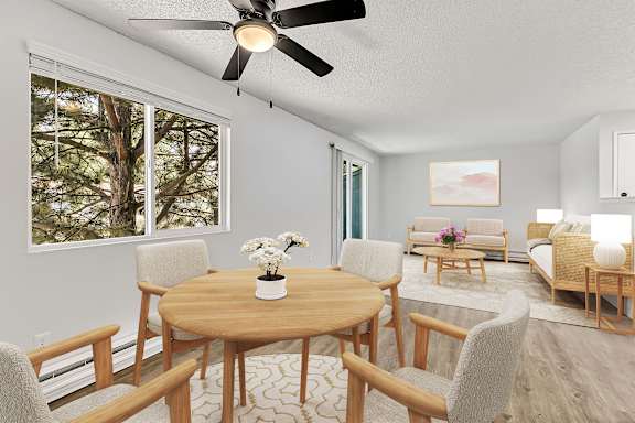 A living room with a wooden table and chairs at the Landing Apartments in Fife, WA..