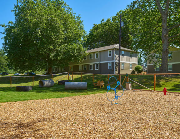 Fully fenced spacious pet park with grass surrounded by trees and the community.at Woodhaven, Everett