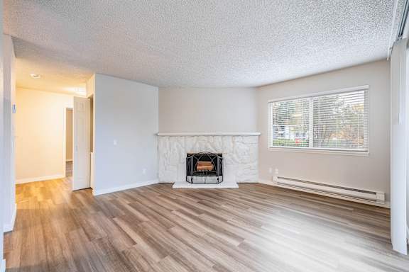A room with a fireplace and wood flooring.