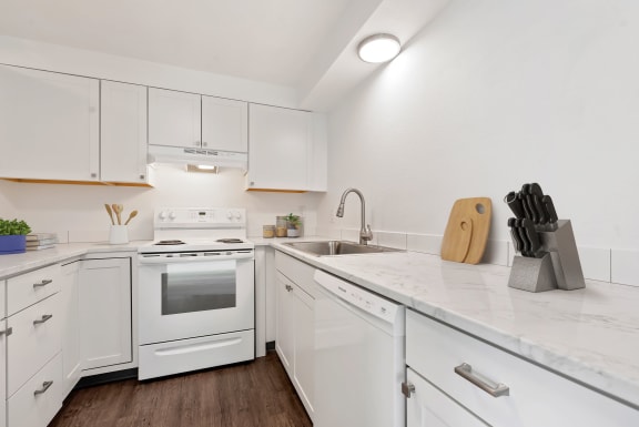Bright and spacious kitchen with white cabinets and appliances. at Talavera, Boise, Idaho