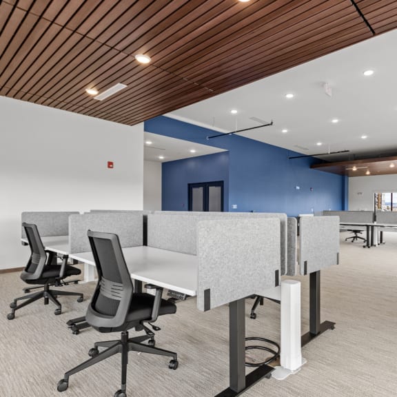 an open office space with desks and chairs and a blue wall at Yellowstone Landing, Belgrade, MT