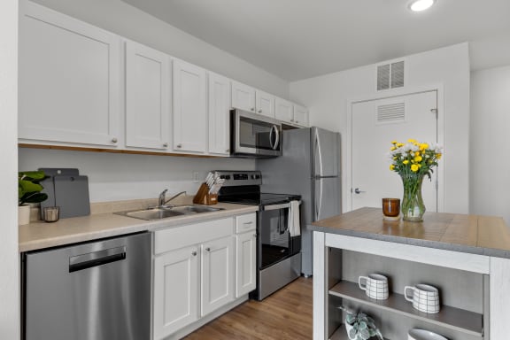 a kitchen with stainless steel appliances and white cabinetry at Yellowstone Landing, Montana