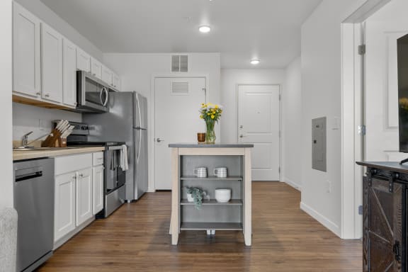 a kitchen with white cabinets and stainless steel appliances  at Yellowstone Landing, Belgrade, MT, 59714