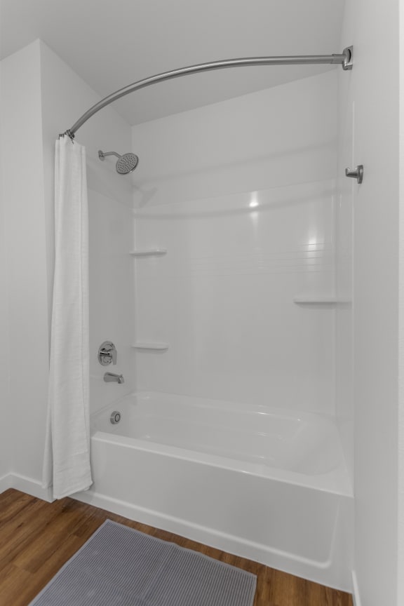 a white shower with a curtain in a white bathroom at Yellowstone Landing, Montana