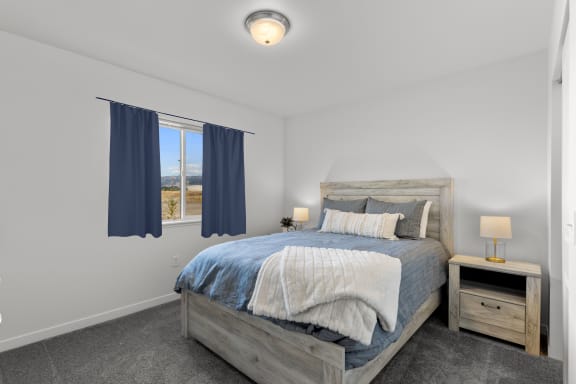a bedroom with a bed and two windows at Yellowstone Landing, Montana