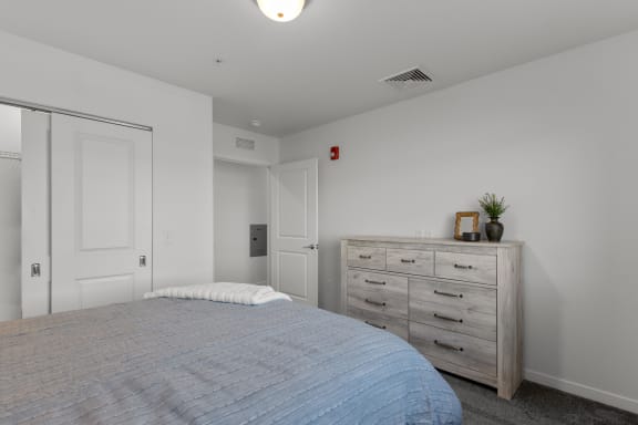 a bedroom with white walls and a bed with a blue blanket at Yellowstone Landing, Belgrade, MT, 59714