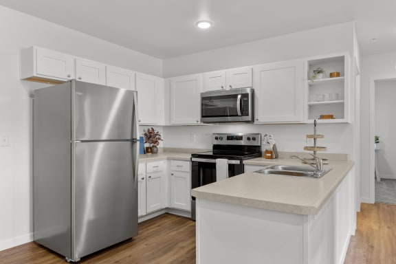a renovated kitchen with stainless steel appliances and white cabinets  at Yellowstone Landing, Belgrade, MT, 59714