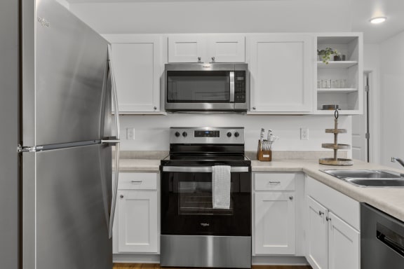 a kitchen with stainless steel appliances and white cabinets at Yellowstone Landing, Belgrade, MT
