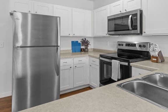 a kitchen with stainless steel appliances and white cabinets at Yellowstone Landing, Montana