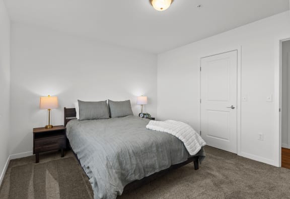 a bedroom with a bed and two lamps and a closet at Yellowstone Landing, Belgrade, 59714