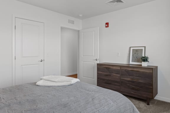 a bedroom with white walls and white doors and a bed with a gray blanket  at Yellowstone Landing, Montana