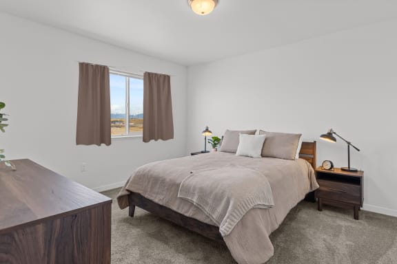 a bedroom with a bed and a desk and a window at Yellowstone Landing, Belgrade, MT