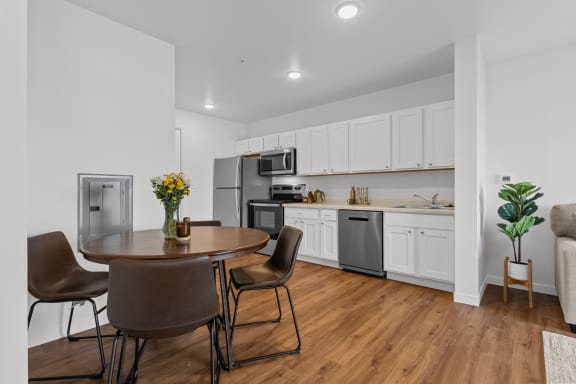 a kitchen and dining room with white cabinets and stainless steel appliances at Yellowstone Landing, Belgrade, 59714