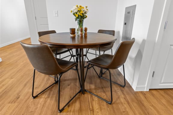 a dining room with a wooden table with four chairs and a vase of flowers at Yellowstone Landing, Belgrade, MT
