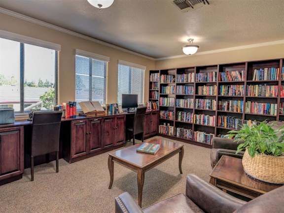 a library with a desk and shelves of books
