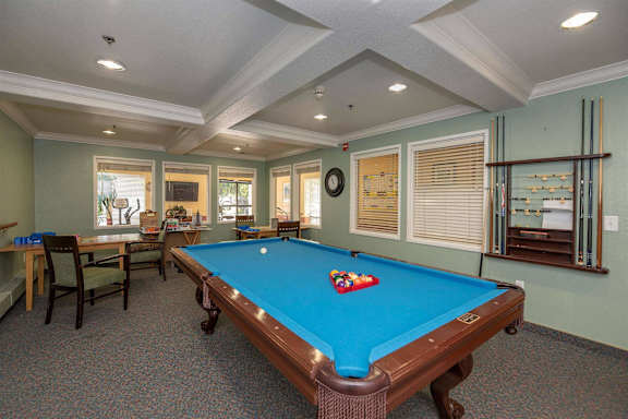 a game room with a pool table and chairs at Campus Commons Senior Living, Sacramento, 95825