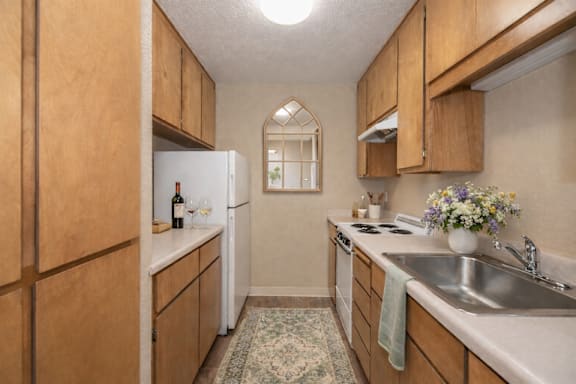 A kitchen with wooden cabinets and a white fridge.