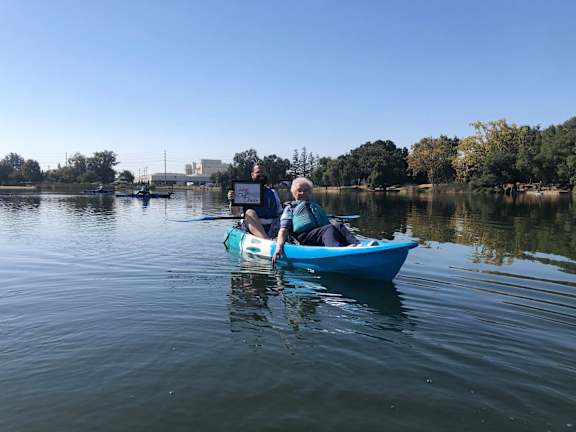 a woman is sitting in a kayak on a lake